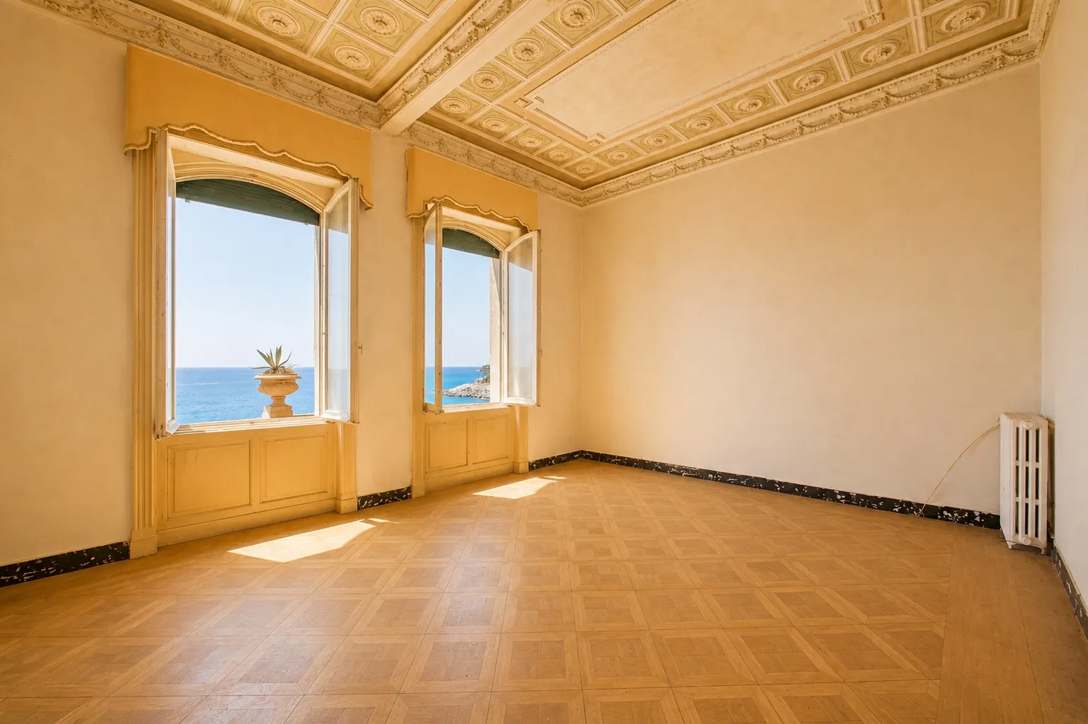 Sala con soffitto a cassettoni e due finestre affacciate sul mare