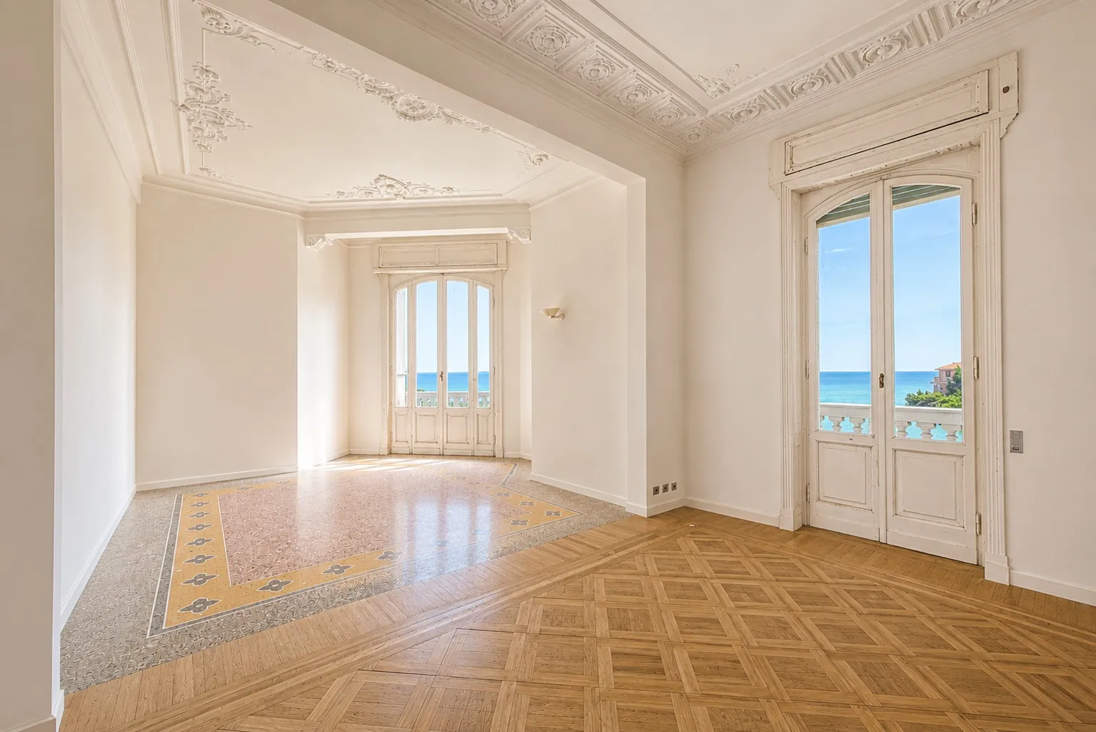 Salone con soffitti decorati, parquet e portefinestre affacciate sul mare