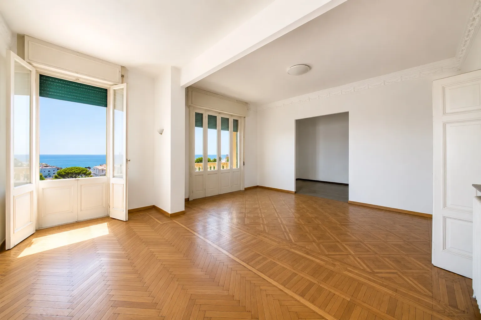 Soggiorno luminoso con parquet e grandi finestre affacciate sul mare
